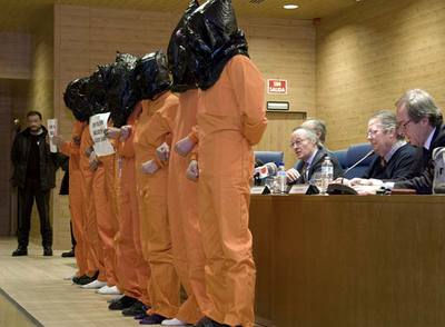 Jóvenes disfrazados de presos con el cartel 