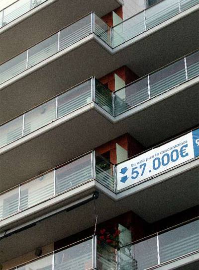 Una promoción de viviendas luciendo carteles de rebajas.