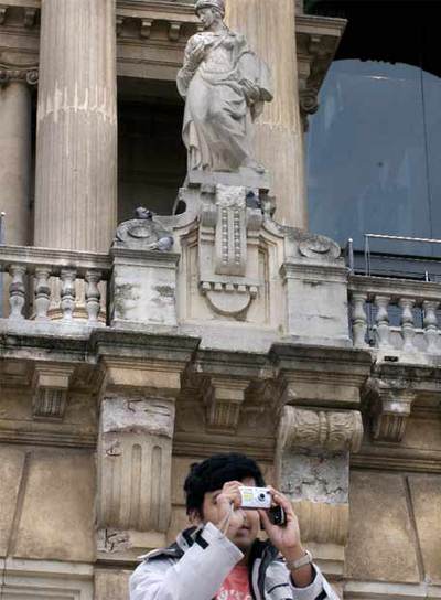 Un visitante ante la fachada en mal estado del MNAC.