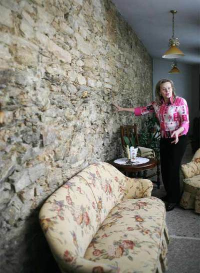 Consuelo Rosende, hija de la propietaria de la vivienda, muestra un tramo de muralla en su salón.