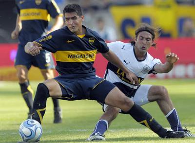 Viatri se lleva el balón ante Rinaudo durante un partido entre el Boca y el Gimnasia.