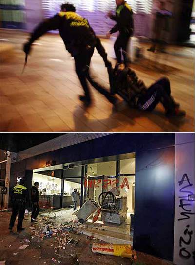 Arriba, dos agentes arrastran a un joven antisistema durante el asalto a la sede de la Policía Municipal de la calle de la Montera. Abajo, estado en el que quedó el lugar después de los altercados.