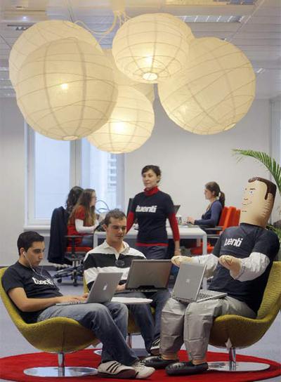 Dos trabajadores de  Tuenti , junto al muñeco que preside la oficina y al que llaman  Percebe. 