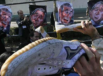 Vecinos de Teherán lanzan sus zapatos contra caricaturas de George W. Bush.