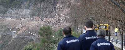 Un grupo de bomberos de la Generalitat, ayer, contemplando el desprendimiento en la zona de Els Degotalls de la montaña de Montserrat.
