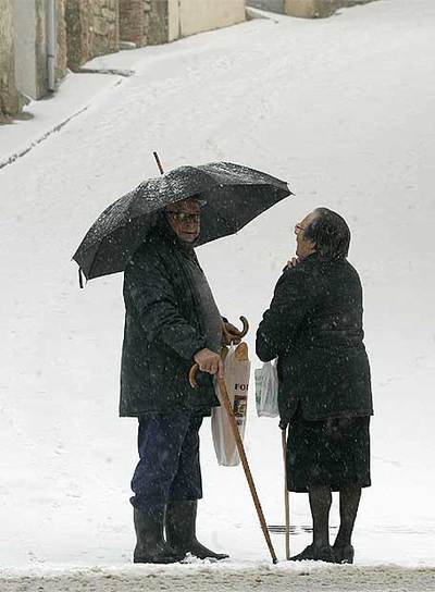 Dos vecinos de Culla (L'Alt Maestrat) conversan, ayer, bajo la nieve.