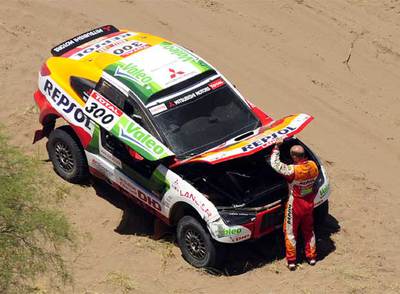 Stéphane Peterhansel revisa el motor de su coche en la etapa de ayer, antes de abandonar.