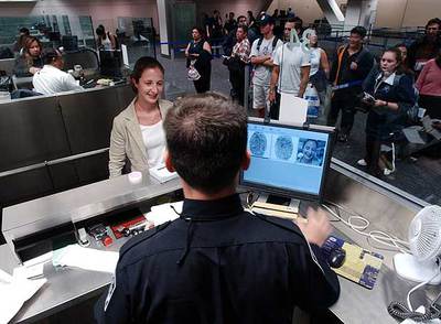 Un agente estadounidense de aduanas toma las huellas dactilares a una pasajera en el aeropuerto de San Francisco.