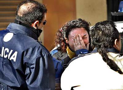 Una amiga de la familia del bebé fallecido era consolada, ayer, por un policía y un vecino en el lugar de los hechos.