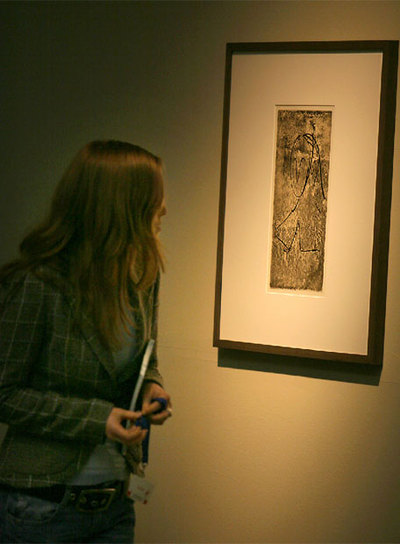 Una visitante observa  Tête de femme,  un grabado de González basado en un dibujo de Picasso.