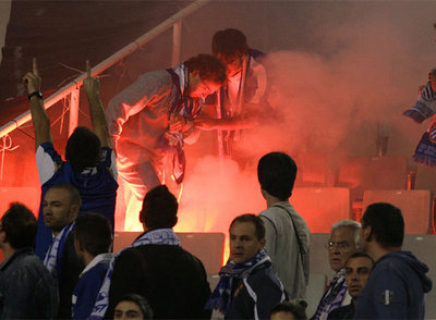 Aficionados del Espanyol intentan apagar las bengalas lanzadas en el partido de la Liga contra el Barça.