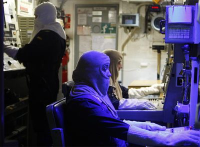 Militares en el centro de información de combate de la fragata  Victoria . Llevan trajes ignífugos por si se incendiaran las máquinas.