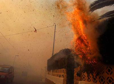 Las llamas alcanzaron ayer una vivienda en La Nucia, que sufrió ayer un incendio provocado por la caída de una torre eléctrica.rnDos vecinos abandonan su domicilio en La Nucia.