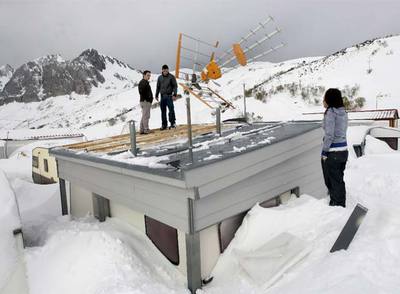 Los propietarios de una caseta en San Isidro (Asturias) observan los daños que el temporal causó en el tejado.