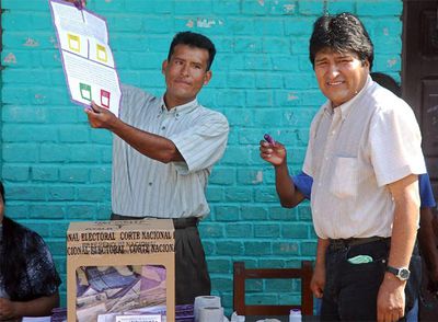 Un miembro de una mesa electoral muestra una papeleta del referéndum a Evo Morales en Chapare.