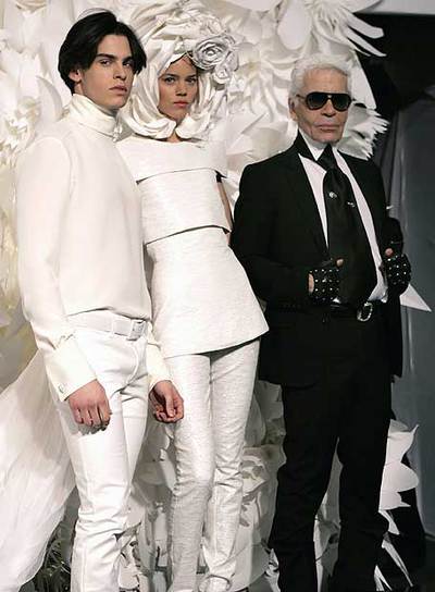 Karl Lagerfeld posa con dos de sus creaciones presentadas ayer en París.