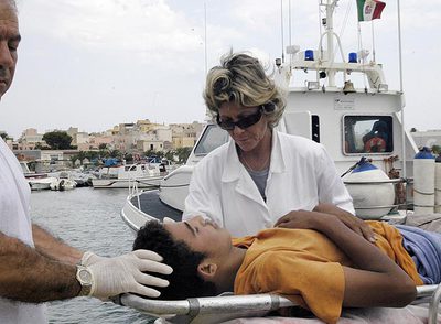 Unos médicos atienden a un  sin papeles   en la isla de Lampedusa.