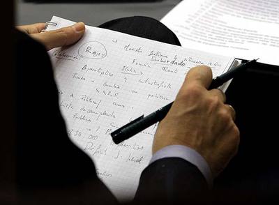 José Luis Rodríguez Zapatero, con un cuaderno de notas, en su escaño durante el debate en el pleno del Congreso sobre la crisis.