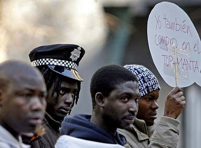 Un grupo de  manteros  se concentró ayer en la Puerta del Sol para pedir la despenalización del  top manta. 