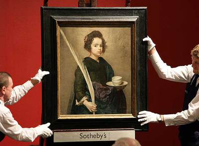 Dos operarios sostienen el cuadro 'Santa Rufina', atribuido a Diego de Velázquez, en la subasta de la casa Sotheby's de Londres en 2007.