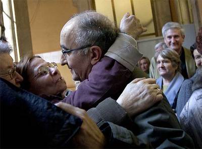 El padre Andreu Oliveras, saludado por una feligresa, ayer a la salida el juicio.