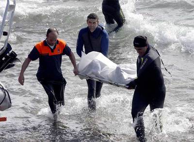 Miembros de los equipos de rescate sacan del mar uno de los 21 cadáveres recuperados.