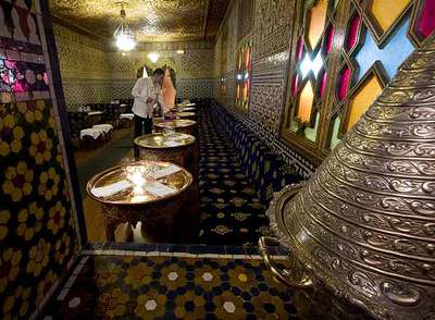 Mesitas bajas, suntuosos mosaicos y paredes de estuco mantienen, desde hace más de 40 años, la esencia de Al Mounia. A la derecha, una tradicional pastela moruna.