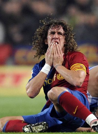 Puyol se lamenta de un golpe en el partido del Barça contra el Espanyol.
