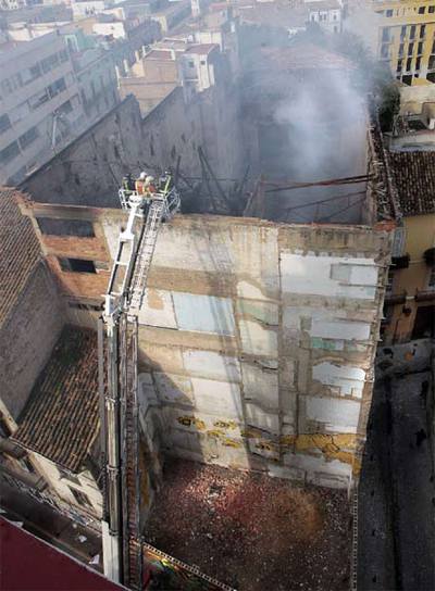 Los bomberos, ayer, ante el edificio del teatro Princesa, hundido por el incendio.