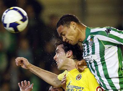 Godin y Oliveira intentan cabecear el balón.