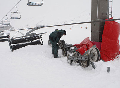 Un operario revisa la pieza cuya rotura motivó el accidente de ayer en la zona de principiantes de Sierra Nevada.