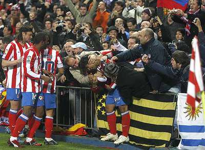 Agüero recibe abrazos de seguidores del Atlético tras marcar el gol del triunfo sobre el Barça.