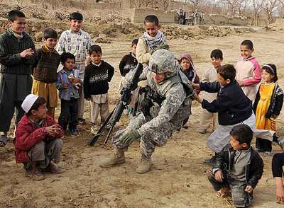 Un soldado de EE UU asignado a las fuerzas de la OTAN en Afganistán juega con unos niños en Bagram (norte del país).