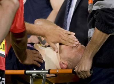 Heitinga es retirado del campo tras su encontronazo con Navarro.