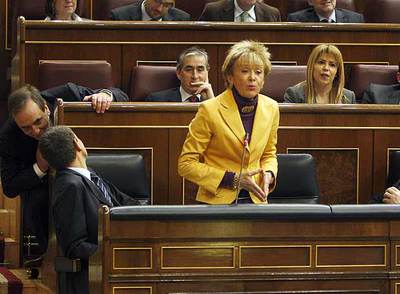 La vicepresidenta Fernández de la Vega, ayer en el pleno del Congreso, entre Zapatero (de espaldas) y Solbes.