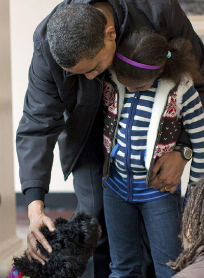Obama, abrazado a su hija pequeña, Sasha, acaricia a  Bo  en presencia de su otra hija, Malia.