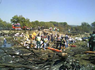 Bomberos y trabajadores de los servicios de emergencia en el lugar donde se estrelló el avión de Spanair.