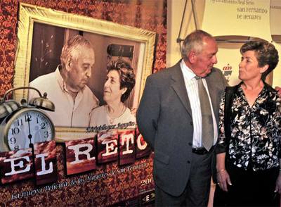 Los intérpretes Manuel Torre y Emiliana Flores posan delante del cartel del corto.