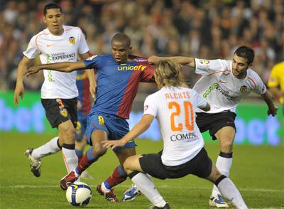 Eto'o trata de superar a Alexis, Maduro y Albiol, que le agarra la camiseta para retenerle.