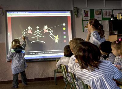 Alumnos de un colegio de Vilassar de Dalt utilizan una pizarra digital.