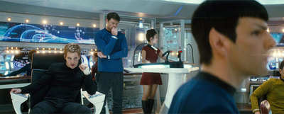 Sentado, a la izquierda, James T. Kirk (Chris Pine); de pie, Leonard  Bones  McCay (Karl Urban); en primer plano Spock (Zachary Quinto), y, a la derecha, Hikaru Sulu (John Cho), en  Star Trek. 