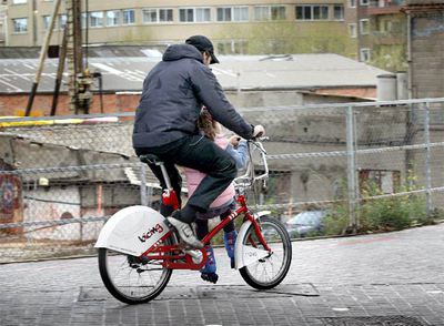 Un hombre con  un niña sentada en la barra de una bicicleta del  Bicing  en Barcelona.