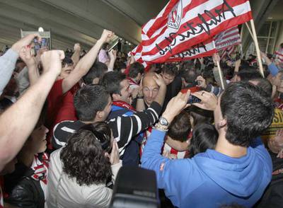 Seguidores del Athletic abrazan a Toquero tras la llegada del equipo al aeropuerto de Bilbao.