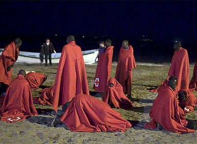 Un grupo de inmigrantes se recupera en una playa de Tenerife de la travesía en patera el pasado febrero.
