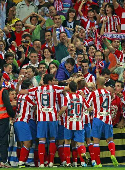 Los jugadores del Atlético abrazan a Forlán tras el gol.