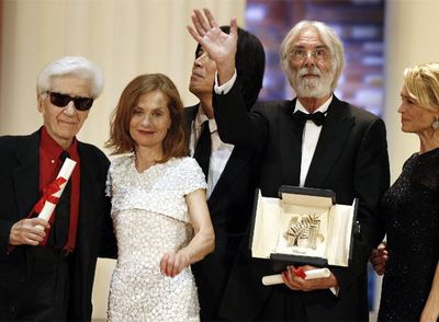 El director Michael Haneke sujeta la Palma de Oro por  Das weisse Band , flanqueado por Isabelle Huppert y Alain Resnais (a su derecha) y Robin Wright.