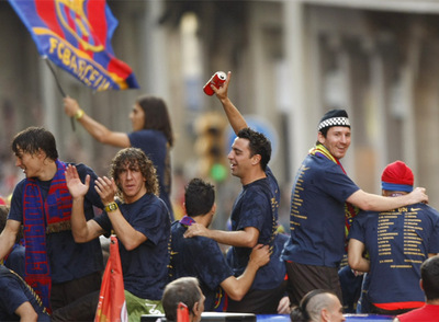 Bojan, Puyol, Xavi y Messi (de izquierda a derecha) responden a los vítoresde los aficionados durante el desfile triunfal del equipo azulgranarnpor las callesrnde Barcelona.
