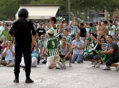 Aficionados béticos, vigilados por la policía al final del partido.