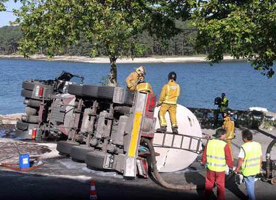 Los bomberos de O Salnés levantan un dique para contener el gasoil derramado e impedir que llegue al mar.