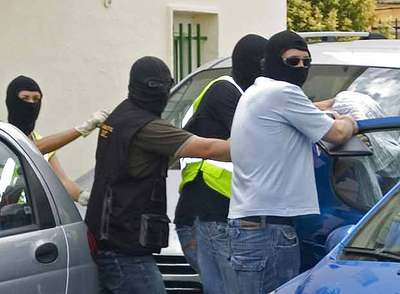 Guardias civiles introducen en un coche a uno de los detenidos en Huelva el pasado sábado.